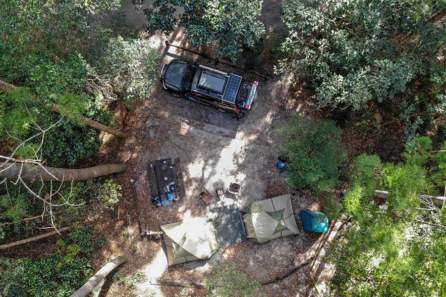 Bird's eye view of two tents setup next to 4wd in a National Park