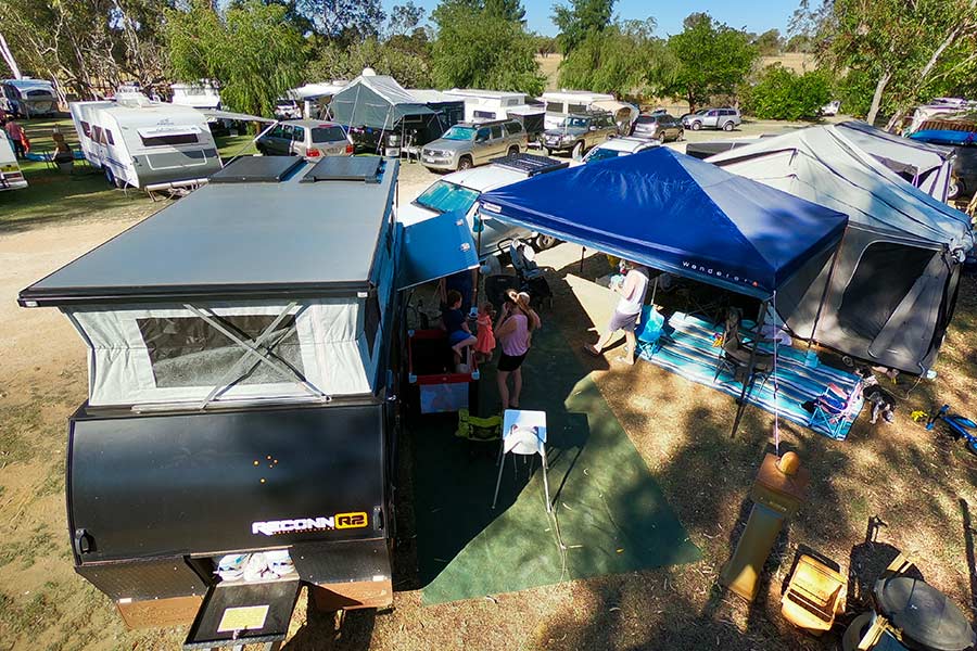 Picture of a crowded caravan park with vehicles, caravans and gazebo's