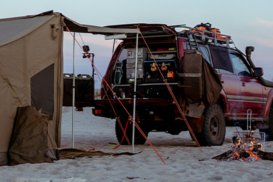 Picture of an Oztent RV tent setup at the rear of a 4WD kitted out with drawers and camp kitchen