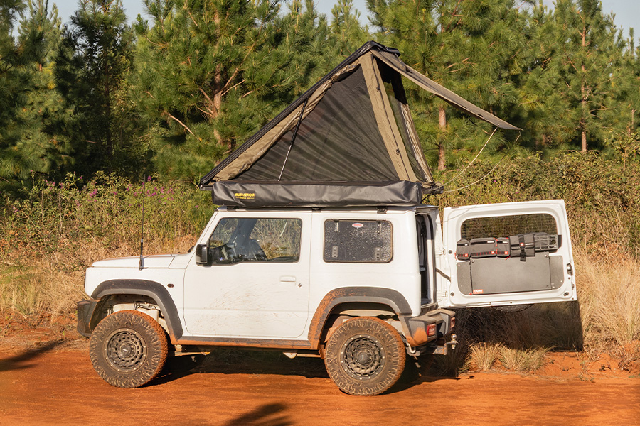 A rooftop tent on top of a 4WD in the dry outback. 